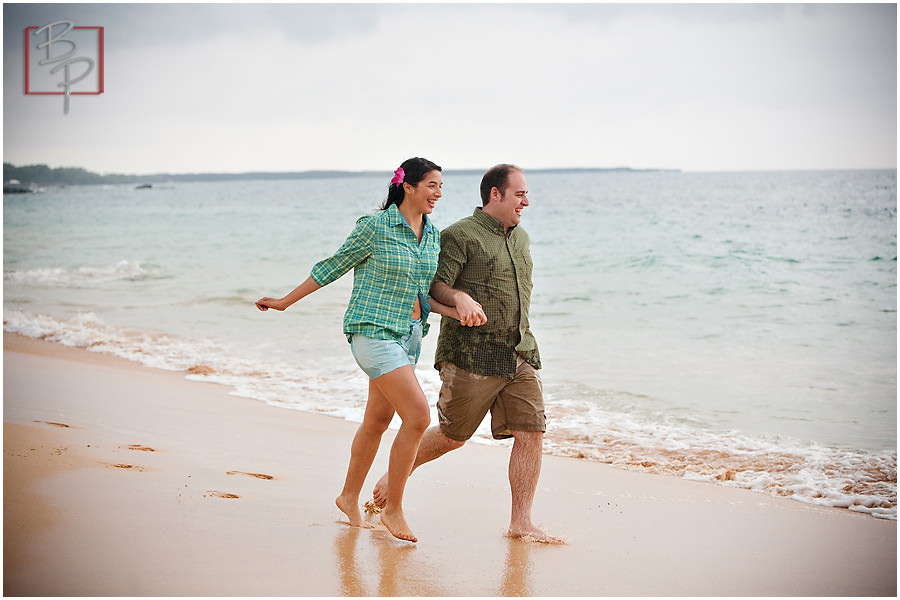 engaged couple running on beach