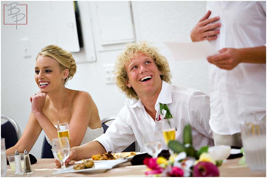 The bride and groom laughing at dinner