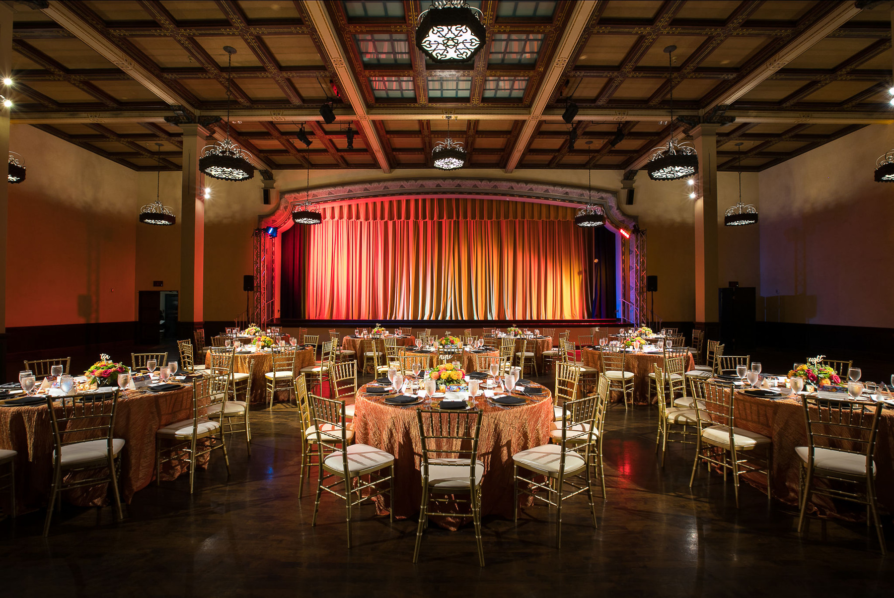 Corporate event ballroom with banquet tables and a stage