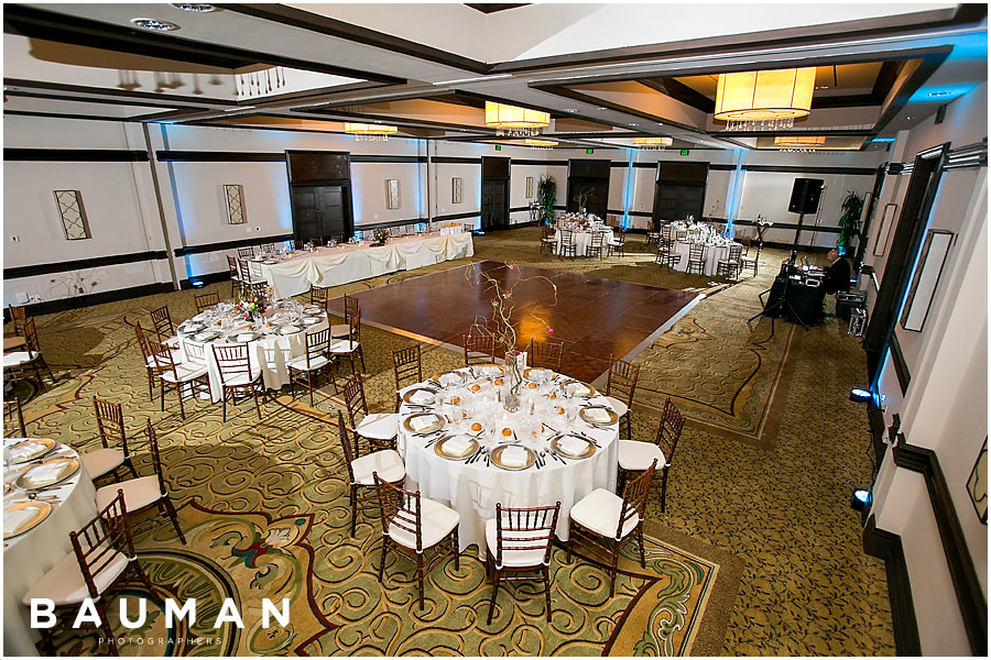 A spacious ballroom filled with elegantly arranged tables and chairs