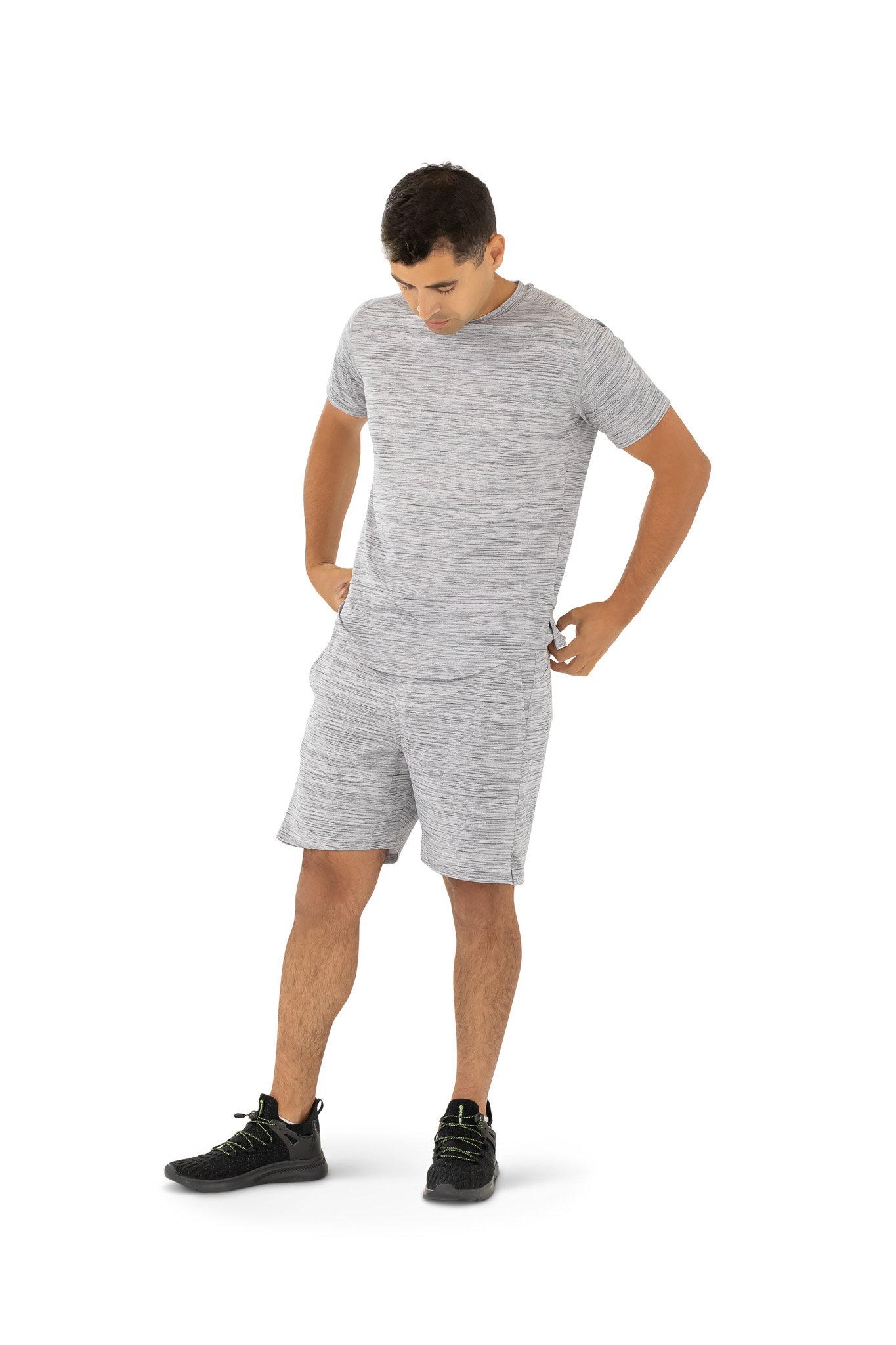 A man in shorts and a t-shirt stands against a plain white background