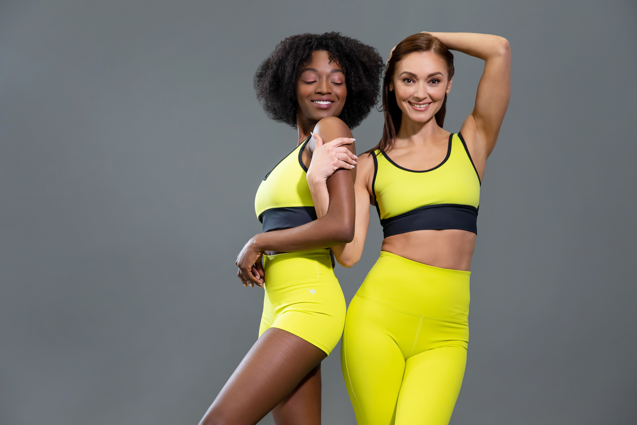 Two models posing in matching neon yellow activewear