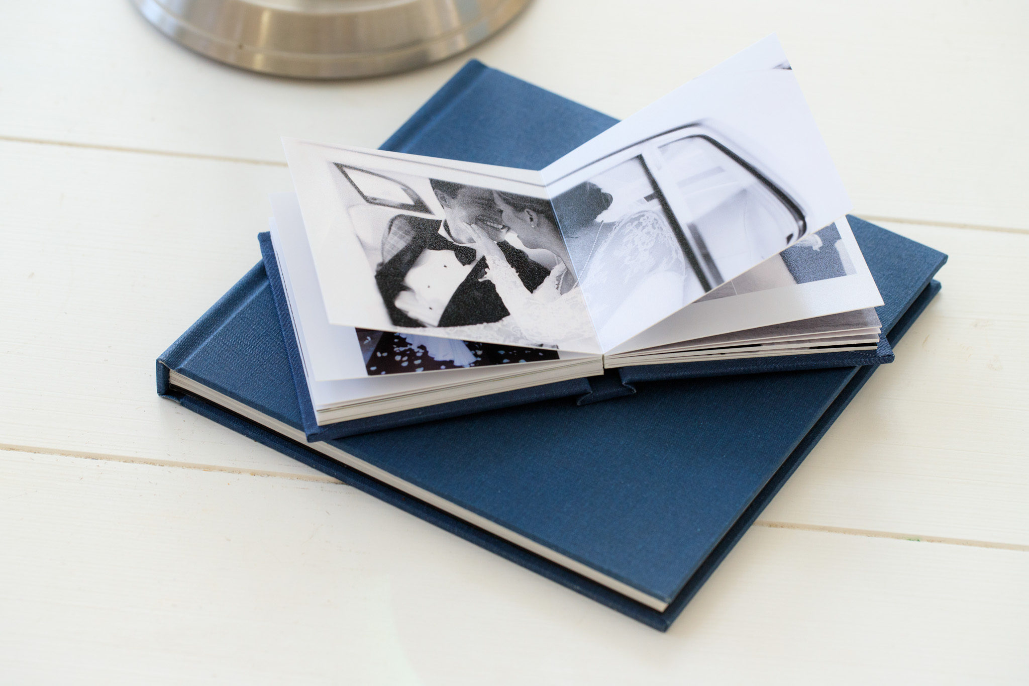 Blue wedding photo album open to black-and-white prints